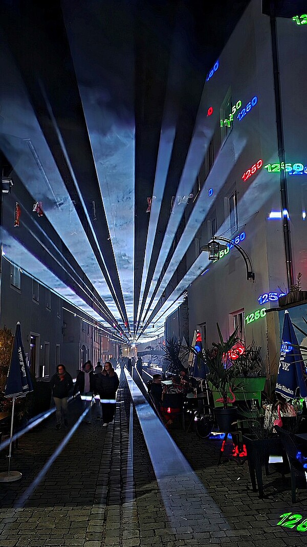 Laserlicht und Schatten von Besuchern erzählen Stadtgeschichte in der Donaugasse Vilshofen. 